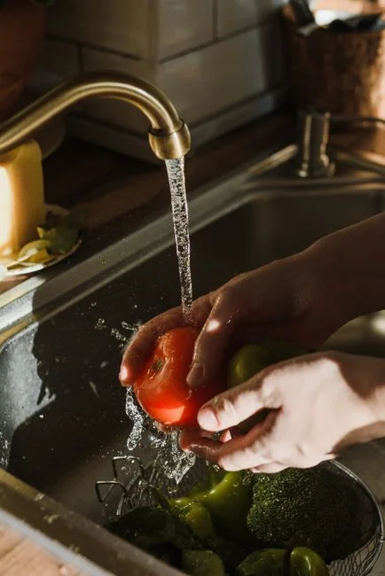 Une cuisine moderne en cours de rénovation, avec un ouvrier, des outils et des matériaux.